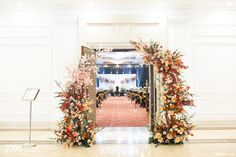 an entrance decorated with flowers and greenery for a wedding ceremony at the grand america hotel