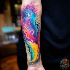 a person with a colorful tattoo on their arm and hand holding something in the other hand