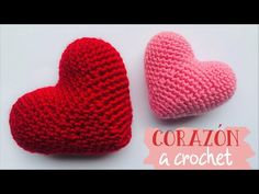 two crocheted hearts sitting next to each other on a white surface with the words diy moda con emii