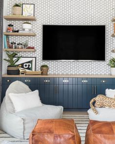 a living room filled with furniture and a flat screen tv mounted to the side of a wall