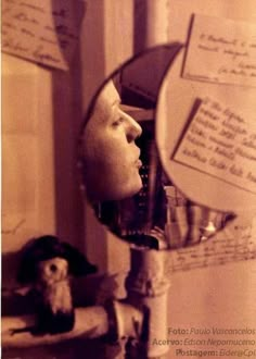 a man's head is reflected in a mirror with writing on the wall behind it