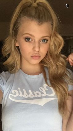 a girl with long blonde hair wearing a t - shirt that says classic on it