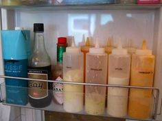 an open refrigerator door with drinks and condiments