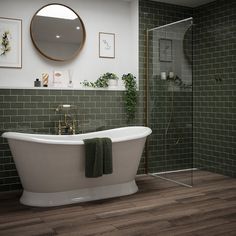 a white bath tub sitting next to a walk in shower under a round mirror on the wall