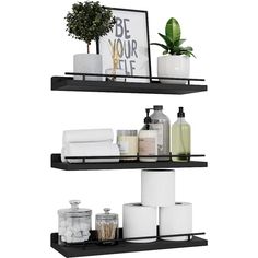 two black shelves with white towels and toiletries on them