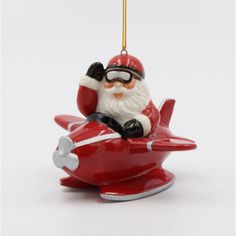 a santa claus ornament sitting on top of a red plane