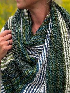 a woman wearing a knitted shawl in green, white and blue stripes on her neck