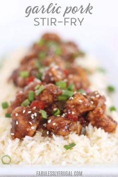 a white plate topped with rice and meat covered in sauce, garnished with green onions