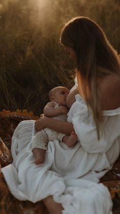 a woman in white dress holding a baby