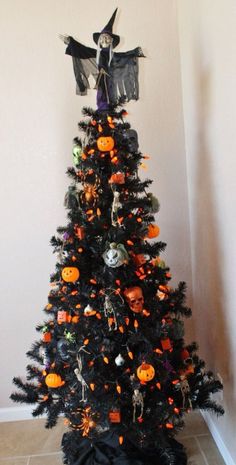 a decorated halloween tree in the corner of a room with orange and black decorations on it