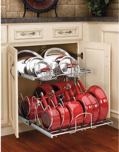 an open dish rack with many pots and pans on it in a white kitchen