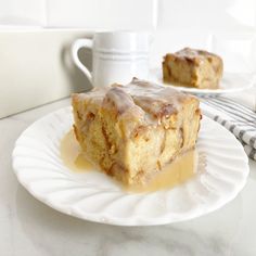 a piece of cake sitting on top of a white plate next to a coffee cup