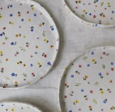 three white plates with colorful flowers on them