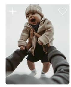 a person holding a baby up in the air