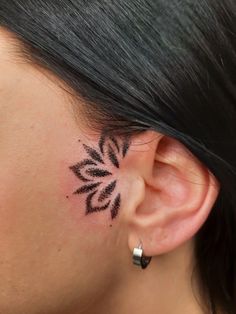 a close up of a person's ear with a tattoo on it