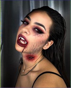 This makeup look perfectly captures the essence of a modern vampire, blending sensuality with a hint of menace. The focal point is the intense eye makeup, featuring dark, smokey eyes with a gradient of red and black eyeshadow that creates a deep, alluring gaze. The use of dramatic false lashes adds volume and intensity to the eyes, making them the centerpiece of this look.   Photo credit by: @manilacarbonaro.mua Vampire Special Fx Makeup, Red Goth Eyeshadow, Horror Vampire Makeup, Halloween Spooky Makeup, Red Black Eye Makeup, Vampire Makeup Looks Halloween, Scary Vampire Costume, Scary Vampire Makeup, Vampire Eye Makeup