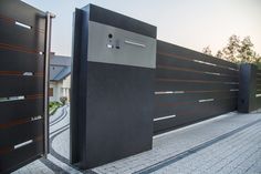 a black and silver gate is next to a brick walkway