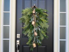 a wreath with bells hanging from it on the front door to greet someone who is waiting for them