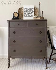 an old dresser is painted brown and has a clock on top