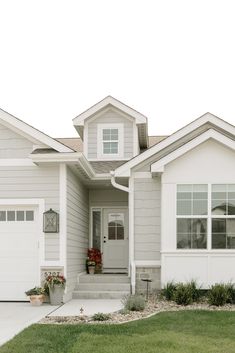 a white house with two garages on the front and one door is open to let in light