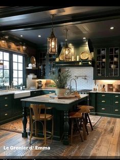 a large kitchen with green cabinets and wooden flooring, along with an island in the middle