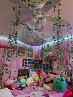 a room filled with lots of stuffed animals and plants hanging from it's ceiling