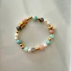 This fresh water pearl and mixed gemstone beaded bracelet features a  mix of 18K gold-filled beads with a fun mix of pastel shades of light greens and peach natural gemstone beads. It is the perfect bracelet to wear alone or add to your bracelet stack. It will make as a great gift to others and even yourself!  Materials: This bracelet features a mixed array of all natural healing gemstones with dainty freshy water pearls and is finished with 18K gold filled hardware.  Gemstones: Aquamarine, Lari Gold Beaded Bracelets With Pearl And Gemstone Beads, Multicolor Pearl Bracelet With Gemstone Beads, Gold Pearl Bracelets With Gemstone Beads, Pearl Beaded Bracelets With Natural Stones, Natural Stone Pearl Beaded Bracelets, House Gift Box, Candy Bracelet, Aquamarine Bracelet, Gemstone Beaded Bracelets