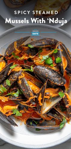 a plate with mussels and sauce on it