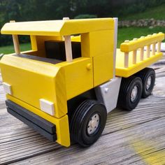 a yellow toy truck sitting on top of a wooden table