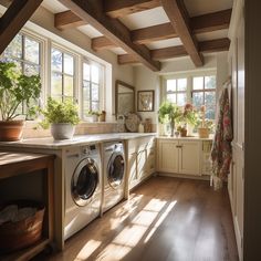 a washer and dryer in a room with wooden floors, windows, and cabinets