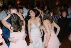 a group of people standing around each other on a dance floor