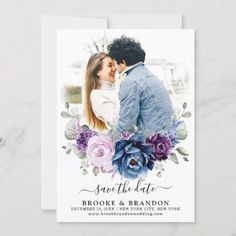 a wedding save the date card with purple flowers and greenery on it, in front of a white background