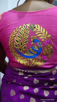 the back of a woman's pink blouse with gold and blue designs