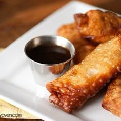 some fried food on a white plate with dipping sauce