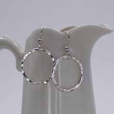 These sparkling handcrafted sterling silver hammered circle hoop earrings will go with any outfit!  Each earring is made from hand forged sterling silver wire, soldered, and hammered for texture and shine.  The circles measure 3/4” and dangles from French ear wires.Material: 925 sterling silver and French ear wiresDimensions: Circle measures 3/4"Matching necklace can be found here https://www.etsy.com/listing/105406282/sterling-silver-eternity-karma-circle* Please read my shop policies for shipp Hand Forged Sterling Silver Hoop Earrings, Hand Forged Sterling Silver Round Hoop Earrings, Sterling Silver Hammered Hoop Earrings, Hammered Hoop Earrings As Gift, Hammered Circle Sterling Silver Earrings, Gift Hammered Hoop Earrings, Silver Hammered Round Hoop Earrings, Hammered Open Circle Hoop Earrings As A Gift, Hammered Open Circle Hoop Earrings For Gift