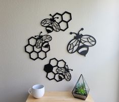 the wall is decorated with metal honeybees and geometric shapes, along with a coffee cup