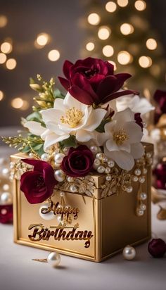 a birthday card box with flowers and pearls on the table next to a christmas tree