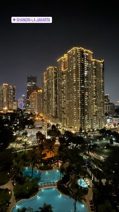 the city is lit up at night with skyscrapers in the backgrounnd