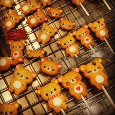 cookies with teddy bears on them sitting on a cooling rack in front of other ones