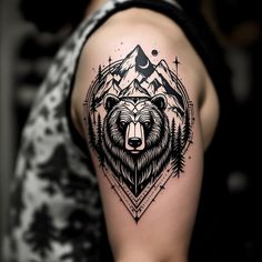 a black and white bear tattoo on the left upper arm with mountains, stars and trees