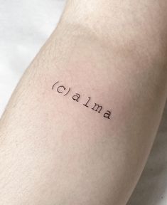 the word calma is written in cursive font on someone's leg