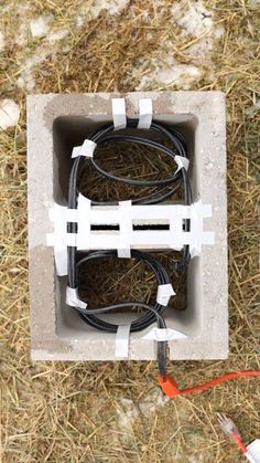 an electrical box with wires in it laying on the ground