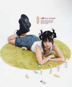 a woman laying on top of a green rug next to toy figurine figures