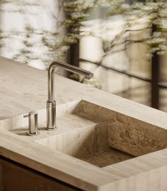 a kitchen sink with a faucet in the middle and a window behind it