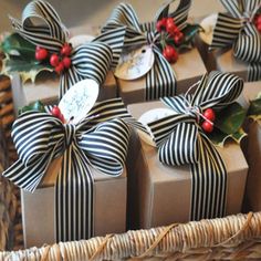 several wrapped presents sitting in a wicker basket with holly and berries on them, all tied together