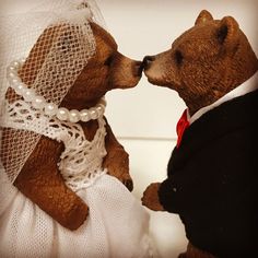 two teddy bears dressed in wedding attire kissing each other