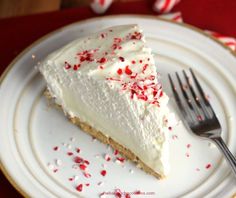 a piece of cake on a plate with a fork and peppermint sprinkles