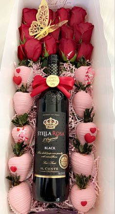 a bottle of wine and some chocolates in a box with roses on the side