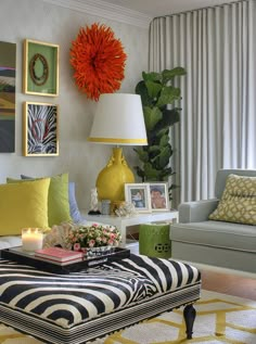 a living room filled with furniture and pictures hanging on the wall above a coffee table