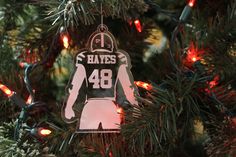 an ornament hanging from a christmas tree that has lights on it and is decorated with a football jersey